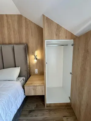 a bedroom with a bed and a mirror next to a door at Apartman Dom in Vareš