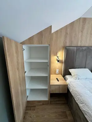 a bedroom with a bed and a book shelf next to a bed at Apartman Dom in Vareš