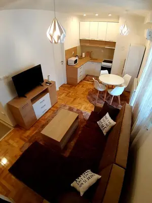 a living room with a couch and a table and a kitchen at Apartment Jelena in Banja Luka
