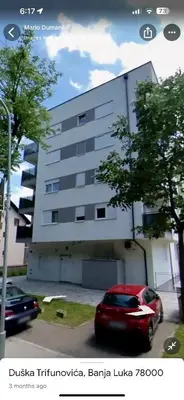 a red car parked in front of a building at Apartment Jelena in Banja Luka