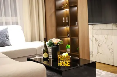 a living room with a couch and a table with a bottle of wine at ModernApartmentsBL in Banja Luka