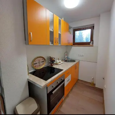 a small kitchen with orange cabinets and a sink at Vikendice Melić in Vlasic