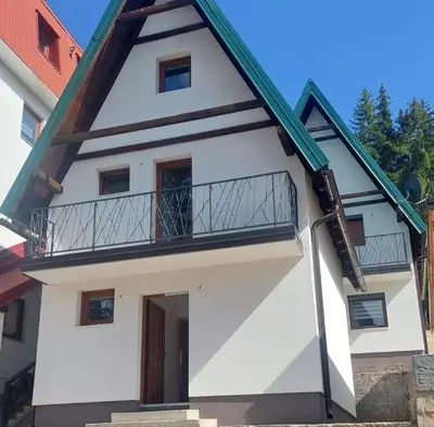 a house with a balcony on the side of it at Vikendice Melić in Vlasic