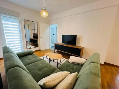 a living room with a green couch and a television at Apartment Gina-Centar in Banja Luka