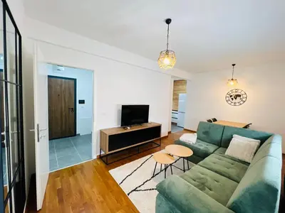 a living room with a green couch and a television at Apartment Gina-Centar in Banja Luka
