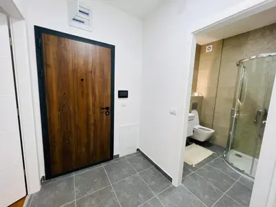 a bathroom with a wooden door and a toilet at Apartment Gina-Centar in Banja Luka