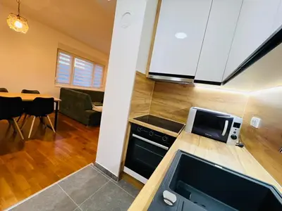 a kitchen with a microwave and a living room at Apartment Gina-Centar in Banja Luka