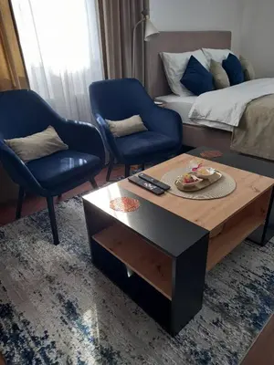 a living room with a coffee table and two chairs at Apartman Mijate in Banja Luka