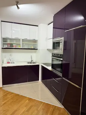 a kitchen with purple cabinets and a microwave at Apartman SLEEP&JOY Tuzla in Tuzla