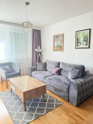 a living room with a couch and a coffee table at Apartman SLEEP&JOY Tuzla in Tuzla