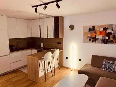a kitchen and living room with a table and chairs at Apartman Alan in Travnik