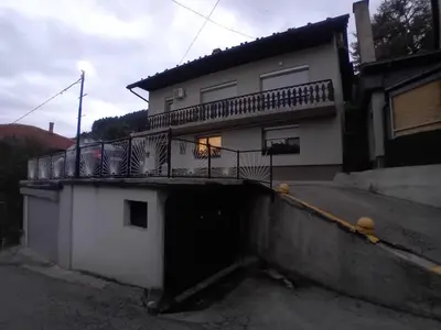 a white house with a balcony on top of it at Apartman Halida in Visoko