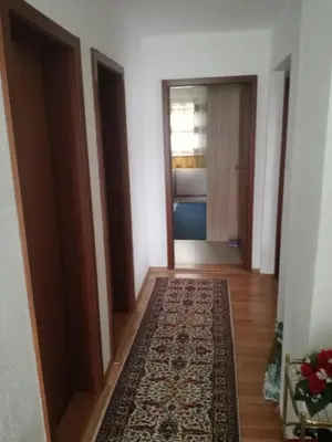a hallway with a rug and a door with a window at Apartman Halida in Visoko