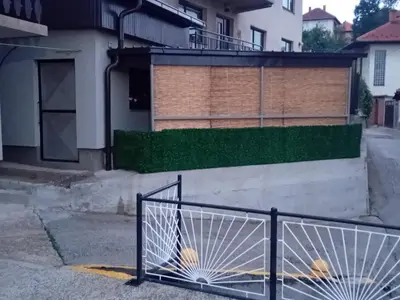 a house with a gate in the street at Apartman Halida in Visoko