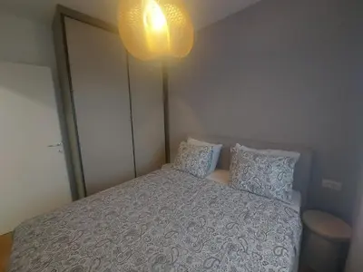 a bedroom with a bed with pillows and a light at BL Lux in Banja Luka