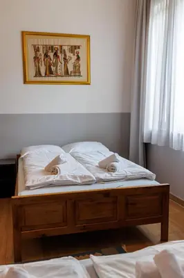 a bed with white sheets and a picture on the wall at Motel Kobilj in Banja Luka