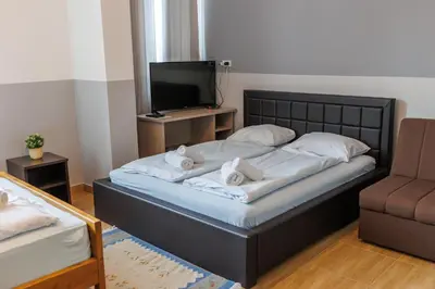 a bedroom with a bed with a tv and a couch at Motel Kobilj in Banja Luka