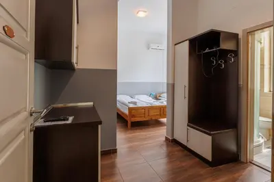 a kitchen with a counter and a room with a bed at Motel Kobilj in Banja Luka
