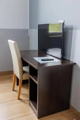 a wooden desk with a chair and a computer monitor at Motel Kobilj in Banja Luka
