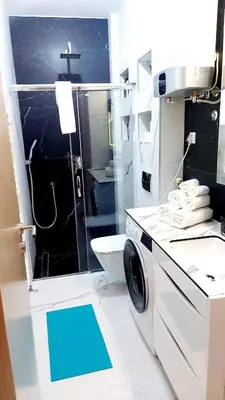 a bathroom with a sink and a washing machine at Apartman 19-Centar in Banja Luka