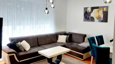 a living room with a brown couch and a table at Apartman 19-Centar in Banja Luka