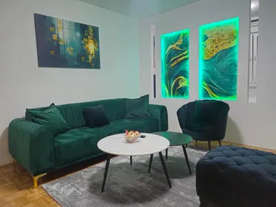 a living room with a green couch and a table at Toskana Tuzla in Tuzla