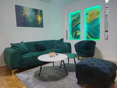 a living room with a green couch and a table at Toskana Tuzla in Tuzla