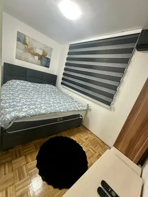 a bedroom with a bed and a black dog laying on the floor at Toskana Tuzla in Tuzla