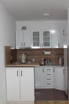 a kitchen with white cabinets and a counter top at Toskana Tuzla in Tuzla