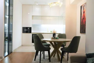 a dining room with a table and green chairs at Palata Gold Apartment in Banja Luka