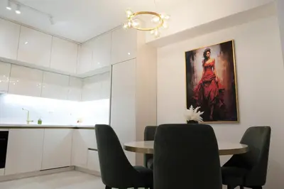 a dining room with a table and a painting on the wall at Palata Gold Apartment in Banja Luka