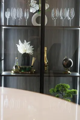 a shelf with wine glasses and flowers on it at Palata Gold Apartment in Banja Luka