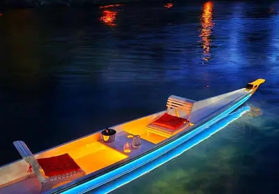 a small yellow boat in the water at night at Palata Gold Apartment in Banja Luka