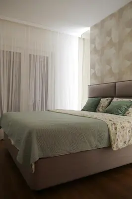 a bedroom with a large bed with green sheets at Palata Gold Apartment in Banja Luka