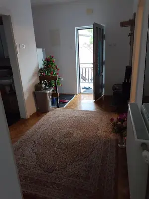 a living room with a rug on the floor and a door at Jasmir in Bihać