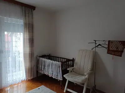 a white chair in a room with a window at Jasmir in Bihać