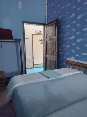 a blue bedroom with a bed and a window at Apartman Retro in Žepče