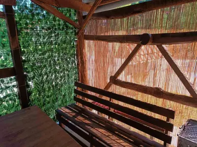 a room with a wooden bench in a straw hut at Apartman Retro in Žepče