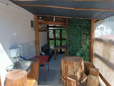 a room with a kitchen with wooden stools and a sink at Apartman Retro in Žepče
