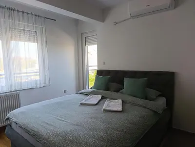 a bedroom with a large bed with two towels on it at Apartman Dunja in Banja Luka