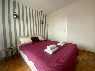 a bedroom with a purple bed with two towels on it at Ellie in Banja Luka