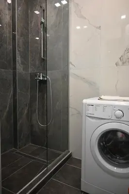 a shower in a bathroom with a washing machine at Ellie in Banja Luka