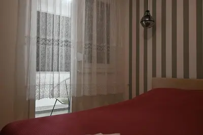 a bedroom with a red bed and a window at Ellie in Banja Luka