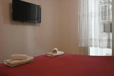 a bedroom with towels on a bed with a flat screen tv at Ellie in Banja Luka