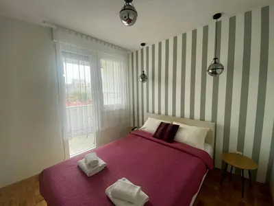 a bedroom with a purple bed with two towels on it at Ellie in Banja Luka