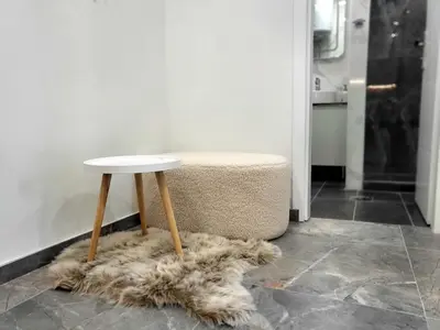 a white table sitting on a furry rug next to a stool at Ellie in Banja Luka