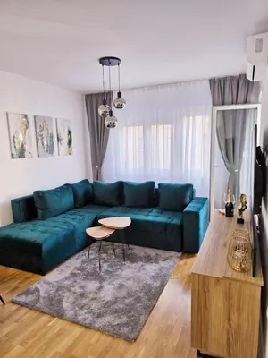 a living room with a blue couch and a table at A LUX APARTMAN Banja Luka in Banja Luka