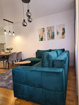 a living room with a blue couch and a table at A LUX APARTMAN Banja Luka in Banja Luka