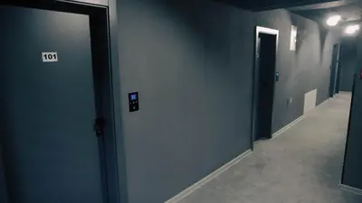 a hallway with blue walls and a door with a sign on it at IB Oil doo Restoran s prenoćištem in Cazin
