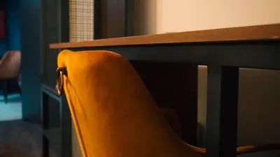 an orange chair sitting next to a desk at IB Oil doo Restoran s prenoćištem in Cazin